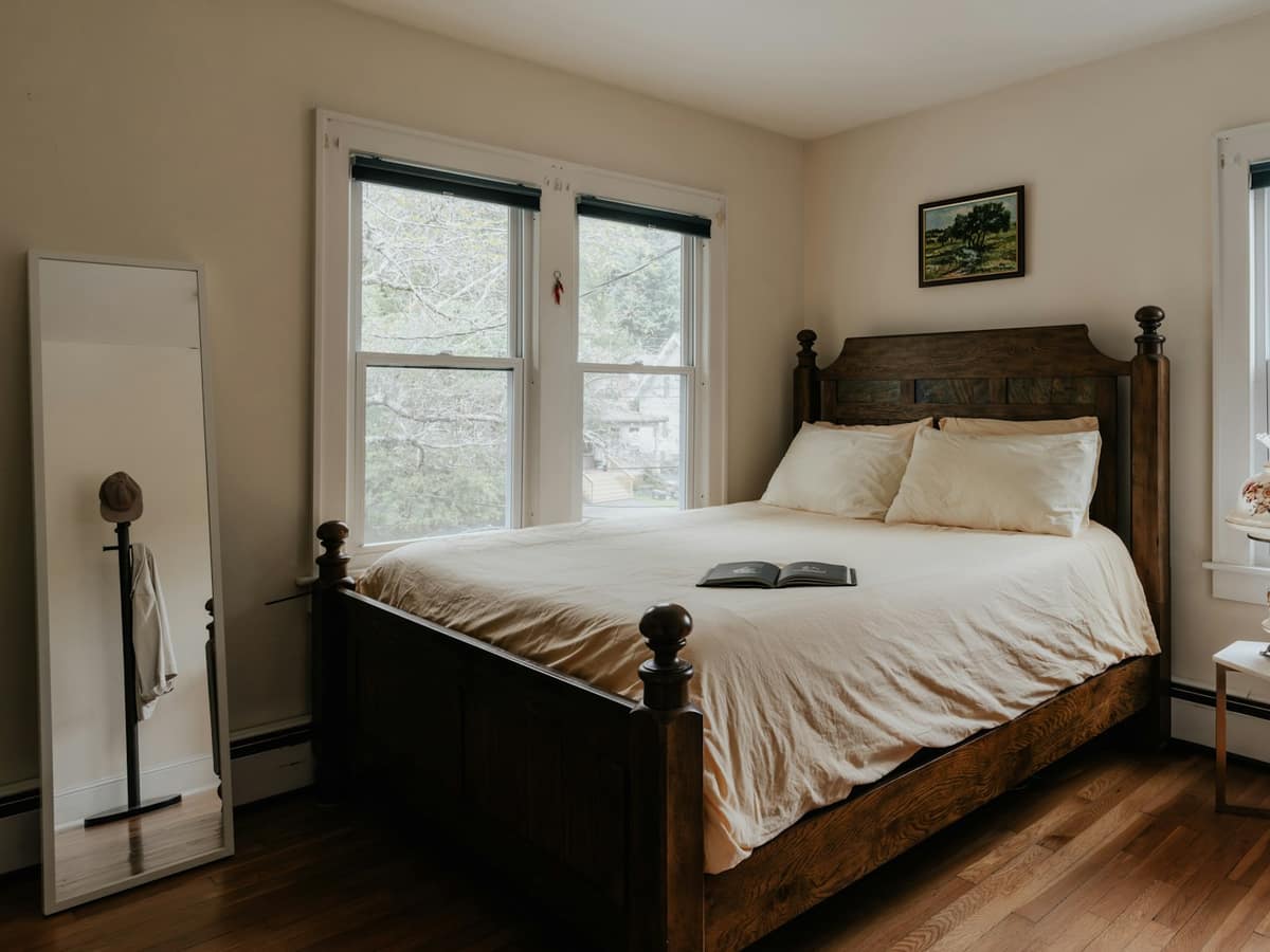The Maigue Room: an old wooden double bed between two tall windows