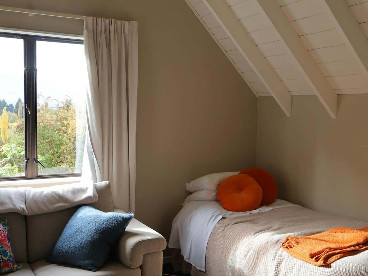 The Snug: a single bed under a sloping ceiling beside a window